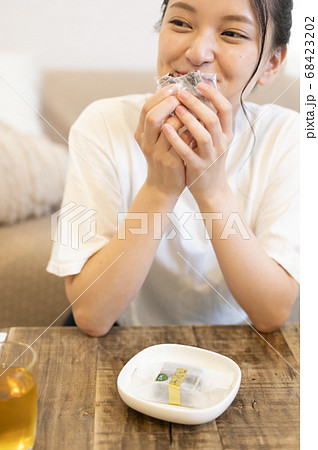 自宅できんつばを食べる若い女性 68423202