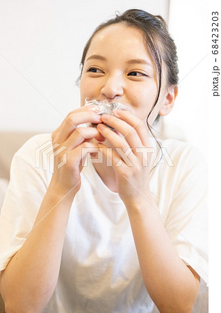 自宅できんつばを食べる若い女性 68423203