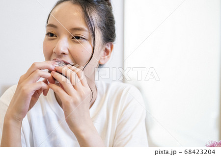 自宅できんつばを食べる若い女性 68423204