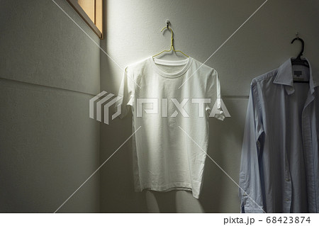 部屋にかけられた一枚の白いtシャツ。部屋、リビング、部屋干し、洗濯など	 68423874