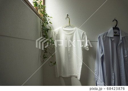 部屋にかけられた一枚の白いtシャツ。部屋、リビング、部屋干し、洗濯など 部屋にかけられた一枚の白いtシャツ。部屋、リビング、部屋干し、洗濯など 68423876
