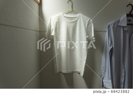 部屋にかけられた一枚の白いtシャツ。部屋、リビング、部屋干し、洗濯など 部屋にかけられた一枚の白いtシャツ。部屋、リビング、部屋干し、洗濯など 68423882