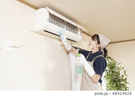 エアコンの清掃をするハウスクリーニングの女性作業員 68424628