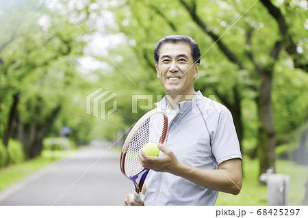 テニスラケットを持って立っているシニアの男性 68425297