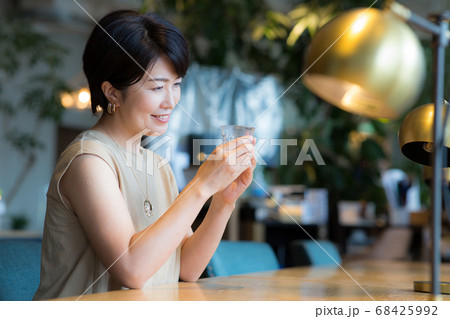 カフェでお冷やを飲むミドル女性 カフェでお冷やを飲むミドル女性 68425992