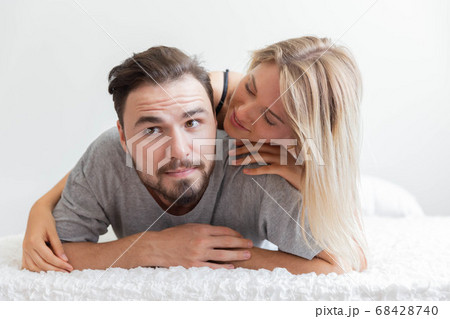 A couple in bed look at camera and smile with 68428740