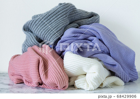 Pile of warm sweaters on marble table. Autumn and winter clothes for donation Pile of warm sweaters on marble table. Autumn and winter clothes for donation 68429906