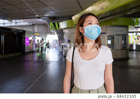 Asian woman wearing surgical mask walking in city 68432105