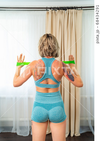 rear view. girl engaged fitness with rubber bands  68434291