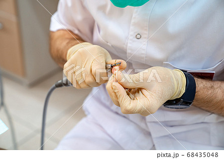 hands dentist adjust the size of the denture. hands dentist adjust the size of the denture. 68435048