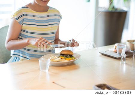 ハンバーガーを食べるミドル女性 68438383