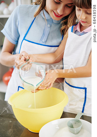 Family making pancake dough 68438598