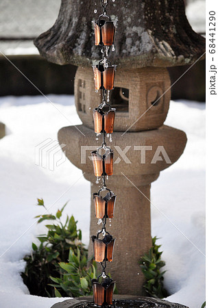 旅館や寺社仏閣で見かける雨どい鎖樋と石灯籠の写真素材