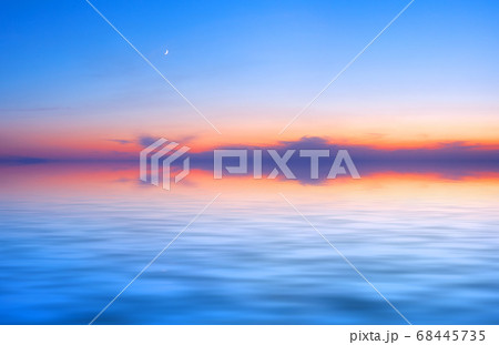 Sunset sky panorama with young moon above water surface Sunset sky panorama with young moon above water surface 68445735