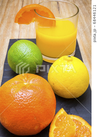 several mature citrus and a glass of juice on a 68446121