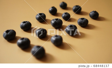 Blueberries are laid out in rows on a gold background 68448137