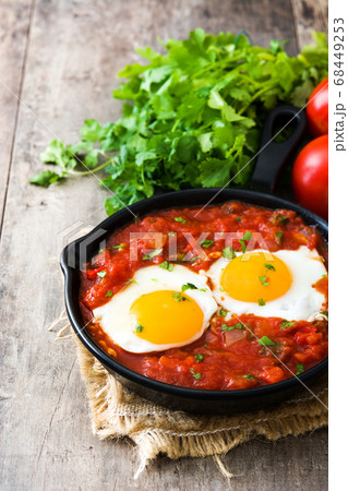 Mexican breakfast: Huevos rancheros in iron frying pan on wooden table	 68449253