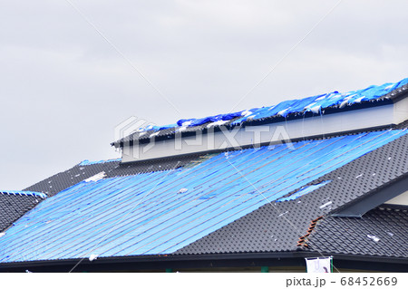 強風被害を受けた屋根の応急処置で張られたブルーシート 68452669