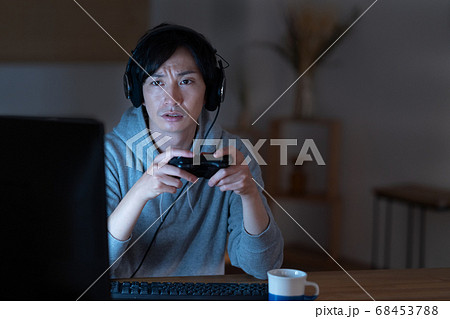 夜中にオンラインゲームをする若い男性 夜中にオンラインゲームをする若い男性 68453788