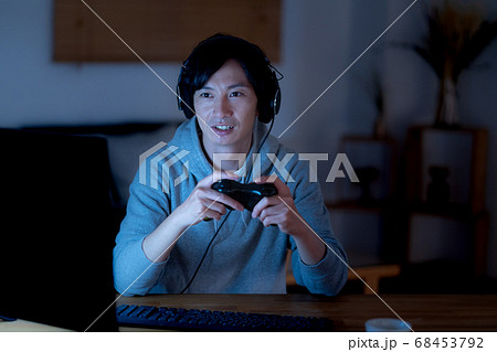 夜中にオンラインゲームをする若い男性 68453792