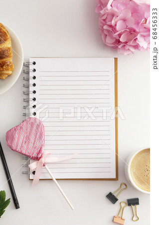 Table top, work space with notebook, cup of coffee and croissant, pink hydrangea. White background. Table top, work space with notebook, cup of coffee and croissant, pink hydrangea. White background. 68456333