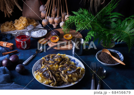 Noodles with poppy seeds, Czech traditional sweet pasta dessert with plum compote, dark background 68456679