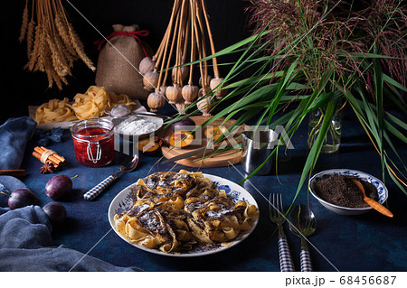 Noodles with poppy seeds, Czech traditional sweet pasta dessert with plum compote, dark background 68456687