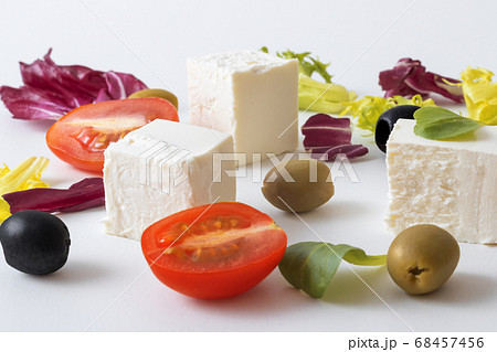 Variation of salads with Greek cheese , green and black olives, lettuce leaves, halfs of cherry tomato. White background.  68457456