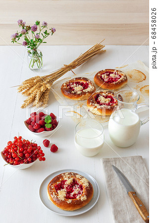White table with yeasty sweet pastry with fresh currants and raspberries and streusel topping. 68458026