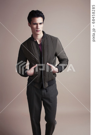 young pretty asian man posing in fashion style on light brown background, lifestyle people concept 68458285