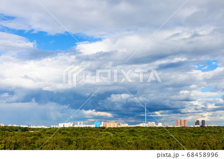 blue cloudy sky over city and green urban park 68458996