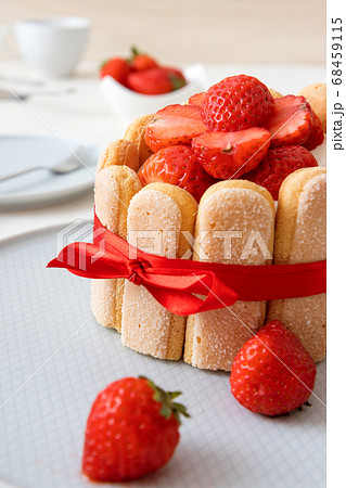 Charlotte, French strawberry dessert, tied up with a scarlet ribbon, cup of coffee, white background 68459115