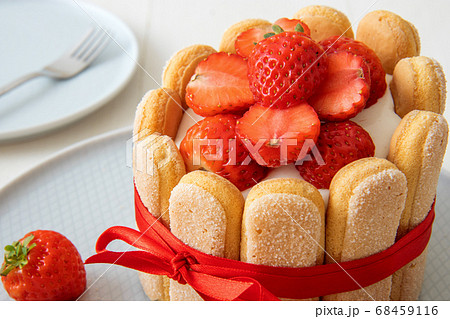 Charlotte, French strawberry dessert, tied up with a scarlet ribbon, cup of coffee, white background Charlotte, French strawberry dessert, tied up with a scarlet ribbon, cup of coffee, white background 68459116