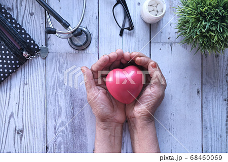 senior women holding red heart in hands senior women holding red heart in hands 68460069
