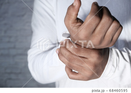 Young man in white shirt suffering wrist pain, close up Young man in white shirt suffering wrist pain, close up 68460595