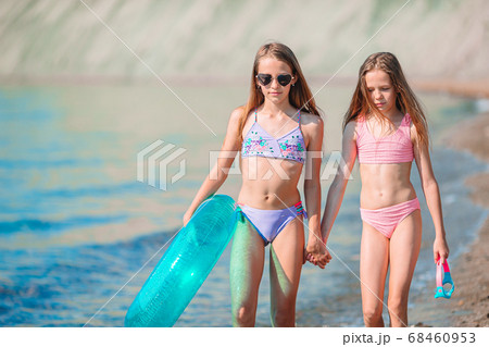 Adorable little girls having fun on the beach Adorable little girls having fun on the beach 68460953