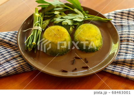 Two portions of frozen green broth on a dark plate, close-up 68463001