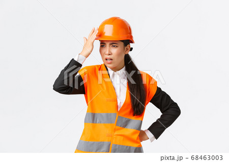 Annoyed and disappointed female asian chief engineer scolding construction workers making stupid mistake, tap helmet and looking bothered, mad at architect, standing white background Annoyed and disappointed female asian chief engineer scolding construction workers making stupid mistake, tap helmet and looking bothered, mad at architect, standing white background 68463003