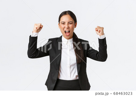 Successful winning businesswoman fist pump and shouting yes from happiness and delighted, achieve goal, celebrating victory, triumphing over prize, standing white background 68463023