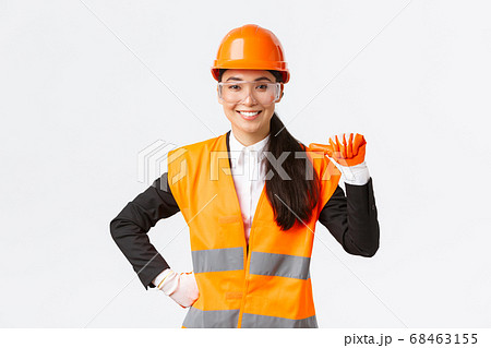 Professional and talented confident smiling asian female engineer, construction architect in safety helmet and glasses, pointing at herself proud, promote own abilities and skills, white background Professional and talented confident smiling asian female engineer, construction architect in safety helmet and glasses, pointing at herself proud, promote own abilities and skills, white background 68463155