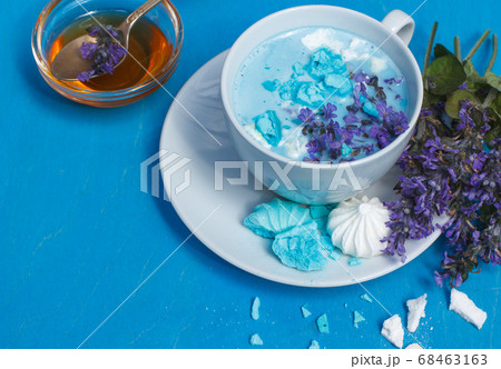 Blue moon milk decorated with mint flowers and meringue crumbs on a bright blue background 68463163