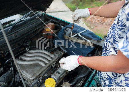 Mechanic hands checking oil level 68464196