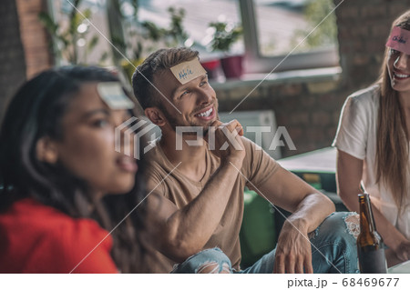 Friends playing a wording game with sticky notes 68469677