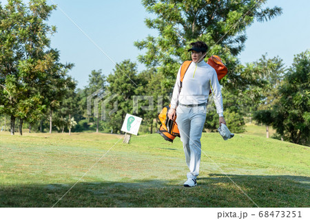 Golfer asian man walking in fairway with bag golf at golf  club.  68473251
