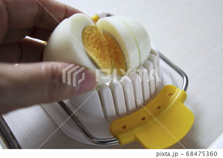 茹で卵をエッグスライサーで切る 68475360