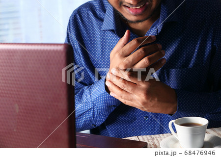 Young man in suffering wrist pain, close up  68476946