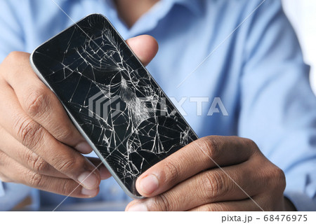 Close up of man hand holding broken smart phone. Close up of man hand holding broken smart phone. 68476975