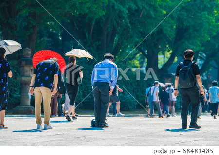 日本の東京都市景観 猛暑の中、靖国神社の大鳥居の下で頭を下げる人たちら=8月15日「終戦の日」 日本の東京都市景観 猛暑の中、靖国神社の大鳥居の下で頭を下げる人たちら=8月15日「終戦の日」 68481485