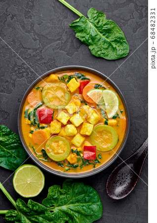 Yellow Veg Thai Curry with Tofu and vegetables in black bowl Yellow Veg Thai Curry with Tofu and vegetables in black bowl 68482331