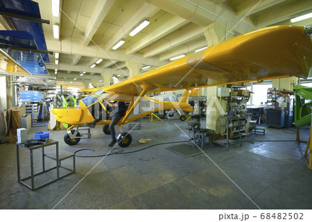 Light planes assembly hall, worker assembling passenger plane 68482502